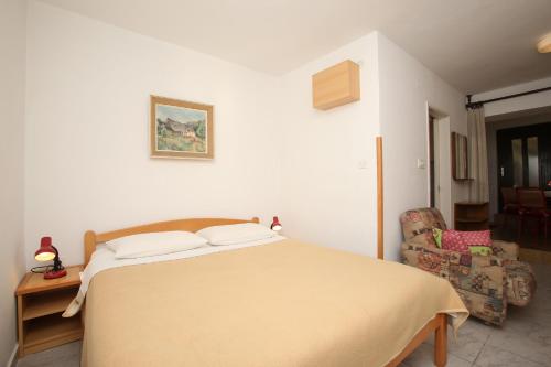 ein Schlafzimmer mit einem großen Bett und einem Stuhl in der Unterkunft Apartments with WiFi Rabac, Labin - 16312 in Rabac