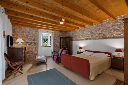 a bedroom with a bed and a stone wall at Seaside house with a swimming pool Sutivan, Brac - 16300 in Sutivan