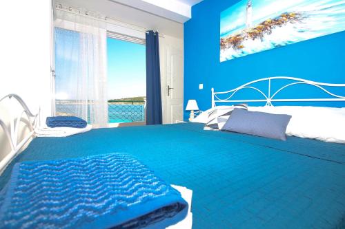 niebieska sypialnia z dużym łóżkiem i niebieską ścianą w obiekcie Seaside house for families with children Kanica, Rogoznica - 16304 w Rogoznicy