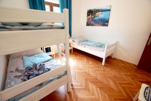 a room with two bunk beds and wooden floors at Holiday house with a parking space Seline, Paklenica - 16318 in Starigrad-Paklenica
