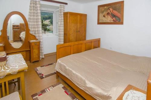 a bedroom with a bed and a mirror at Seaside holiday house Trstenik, Peljesac - 16309 in Trstenik