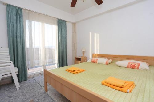 una camera da letto con un grande letto con asciugamani arancioni di Apartments with a parking space Kastel Stari, Kastela - 16344 a Kaštela (Castelli)