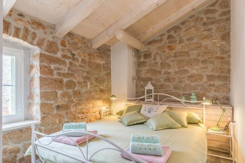a bedroom with a bed in a stone wall at Family friendly house with a swimming pool Cerion, Central Istria - Sredisnja Istra - 16332 in Višnjan