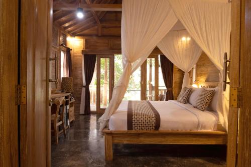 un dormitorio con una cama con dosel en Homayoon Private Villa Ubud, en Ubud