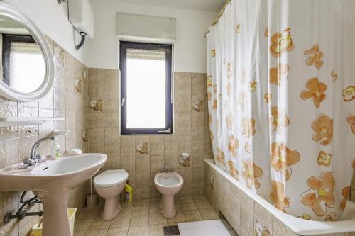 La salle de bains est pourvue d'un lavabo, de toilettes et d'une douche. dans l'établissement Apartments with a parking space Umag - 16354, à Umag