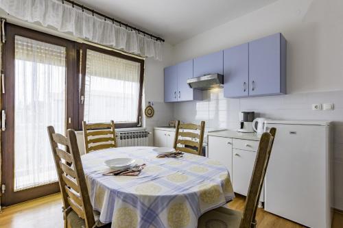 Il comprend une cuisine équipée d'une table et d'un réfrigérateur blanc. dans l'établissement Apartments with a parking space Umag - 16354, à Umag