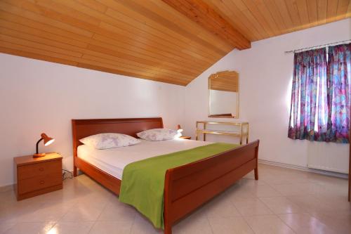 een slaapkamer met een groot bed en een houten plafond bij Apartments by the sea Duce, Omis - 16406 in Duće