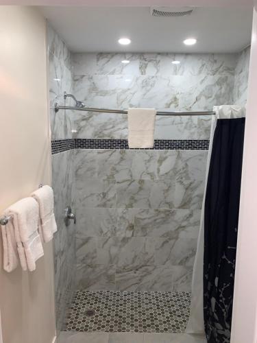 a bathroom with a shower with white marble at Westport Station Motel in Westport