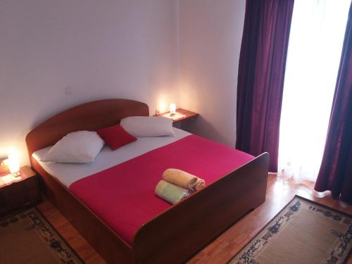 - une chambre avec un grand lit et une couverture rose dans l'établissement Apartments by the sea Pisak, Omis - 16411, à Mimice