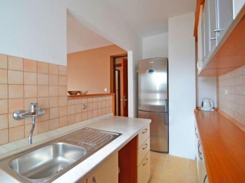 a kitchen with a sink and a stainless steel refrigerator at Apartments by the sea Zadar - Diklo, Zadar - 16419 in Zadar