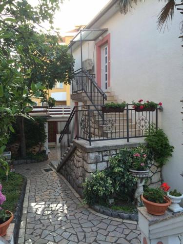 a house with a staircase and some plants and flowers at Apartments by the sea Selce, Crikvenica - 16375 in Selce