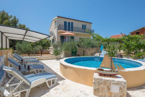 una piscina con sillas y un barco de juguete en un patio en Holiday house with a swimming pool Rogac, Solta - 16444 en Grohote