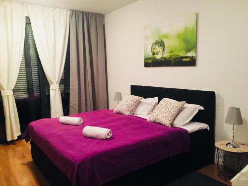 a bedroom with a purple bed with two towels on it at Apartments with WiFi Zagreb - 16462 in Zagreb