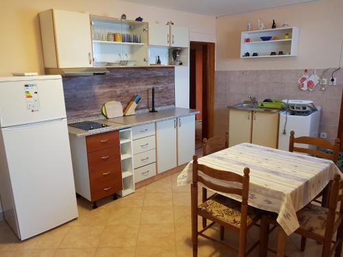 a kitchen with a table and a white refrigerator at Apartments with a parking space Tar, Porec - 16475 in Tar