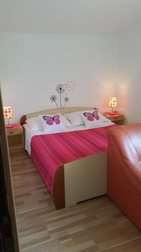 a large bed in a room with two lamps at Apartments with parking space Kolan, Pag - 16482 in Kolan