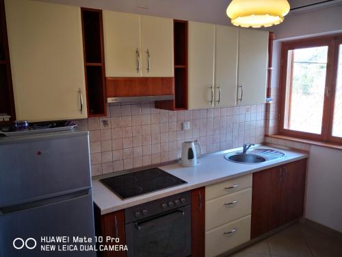 cocina con fregadero y fogones horno superior en Apartments with a parking space Seget Vranjica, Trogir - 14212, en Seget Vranjica