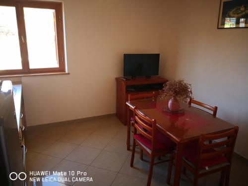 comedor con mesa y TV en Apartments with a parking space Seget Vranjica, Trogir - 14212, en Seget Vranjica