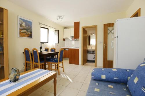 eine Küche und ein Esszimmer mit einem Tisch und einem Kühlschrank in der Unterkunft Apartments with a parking space Mali Iz (Iz) - 16535 in Veli Iž