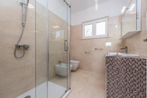 a bathroom with a glass shower and a toilet at Holiday house with a parking space Vrsi - Mulo, Zadar - 16527 in Vrsi