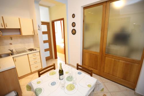 a kitchen with a table with a bottle of wine on it at Apartment Mali Iz 16535b in Veli Iž