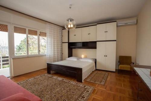 sypialnia z łóżkiem i dużym oknem w obiekcie Apartments by the sea Klimno, Krk - 16577 w mieście Dobrinj