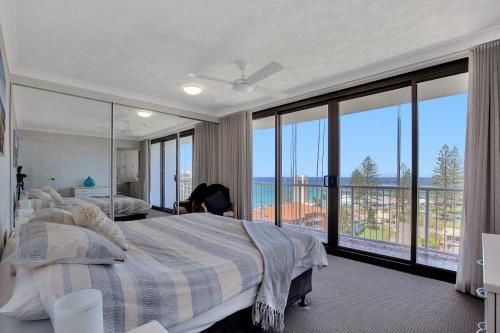 a bedroom with a bed with a view of the ocean at Carool Holiday Apartments in Gold Coast