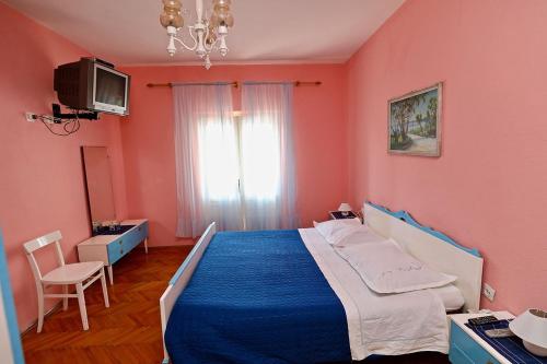 - une chambre avec un lit bleu et des murs roses dans l'établissement Apartments by the sea Sucuraj, Hvar - 16404, à Sućuraj