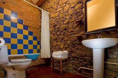 une salle de bain en pierre avec toilettes et lavabo dans l'établissement Casa Rural Finca Valvellidos, à Jaraiz de la Vera