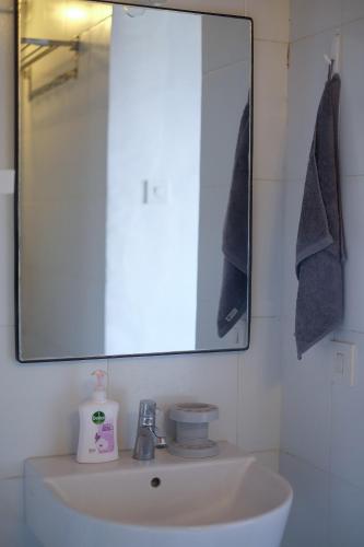 a bathroom with a sink and a mirror at Dip & Doze Living in Canggu
