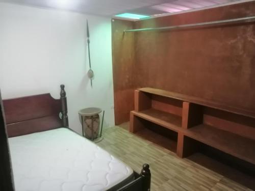 ApartaRefugio EL RETIRO VERDE 2 في ليتيسيا: غرفة نوم بسرير وجدار خشبي