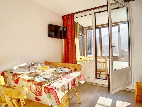 une salle à manger avec une table et des chaises et une fenêtre dans l'établissement Studio lumineux skis aux pieds avec balcon et WIFI - FR-1-344-902, aux Menuires