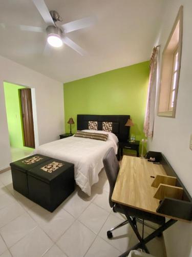 a bedroom with a bed and a green wall at Casa Margarita Oaxaca in Oaxaca City