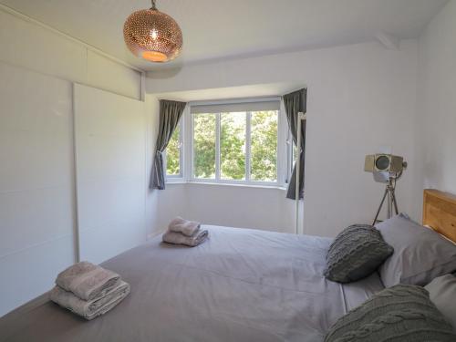 ein Schlafzimmer mit einem großen Bett mit Handtüchern darauf in der Unterkunft Hunter's Cottage in Windermere