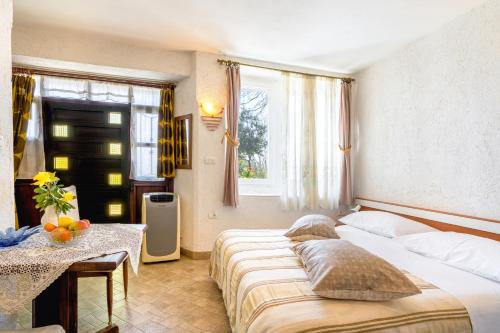 莫托文的住宿－Apartments with a parking space Motovun, Central Istria - Sredisnja Istra - 14160，一间卧室设有两张床、一张桌子和一个窗口
