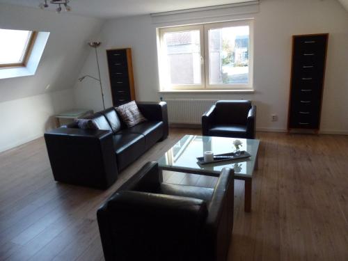 a living room with two couches and a coffee table at Schiphol Apartments in Aalsmeer