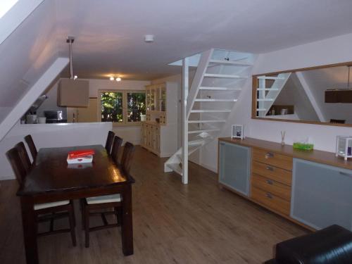 een keuken en eetkamer met een tafel en een trap bij Schiphol Apartments in Aalsmeer