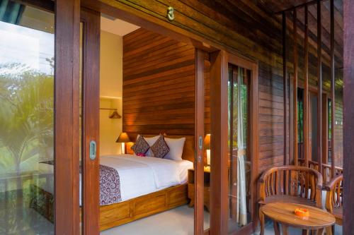 - une chambre avec un lit sur une terrasse couverte dans l'établissement Karang Agartha Lembongan, à Nusa Lembongan