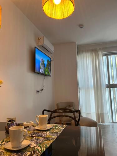 a living room with a table and a television on the wall at Plano Vertical in San Miguel de Tucumán