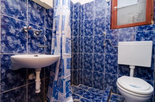 a blue tiled bathroom with a toilet and a sink at Apartments by the sea Cove Pjestata, Peljesac - 14440 in Ston