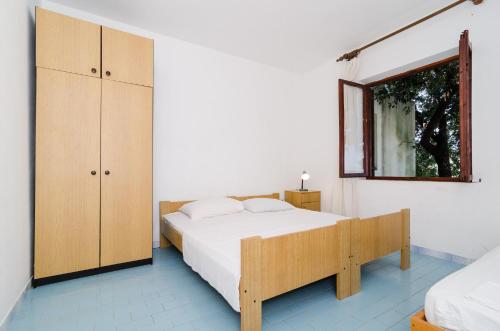 a bedroom with a white bed and a mirror at Apartments by the sea Cove Pjestata, Peljesac - 14440 in Ston