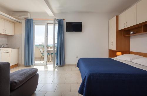 a bedroom with a bed and a kitchen with a balcony at Apartments with a parking space Tucepi, Makarska - 14457 in Tučepi