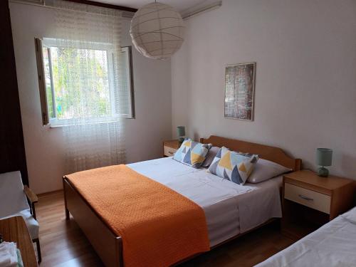 - une chambre avec un grand lit et une couverture orange dans l'établissement Apartment Mira - affordable & comfortable, à Supetar