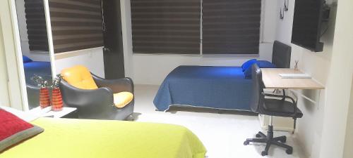 a bedroom with a bed and a desk and a chair at Casa Boutique HNP in Barrancabermeja