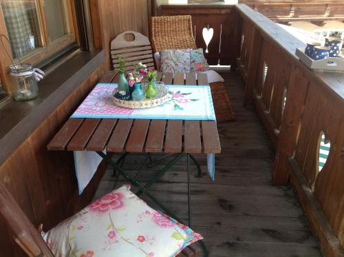 un balcón con mesa y sillas en el porche en Ferienwohnung Dorfpub en Neustift im Stubaital