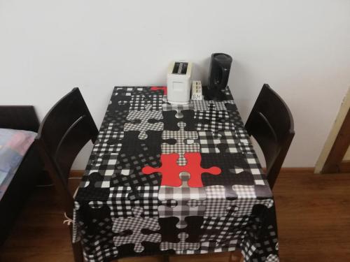 una mesa con un mantel blanco y negro con un rompecabezas rojo en Guest Room Asparuh, en Troyan