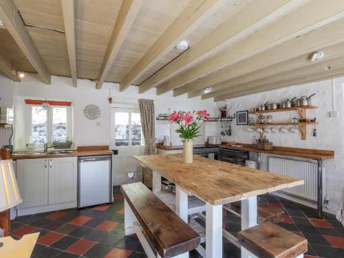 a large kitchen with a wooden table and benches at Sycamore Vestry in Fishguard