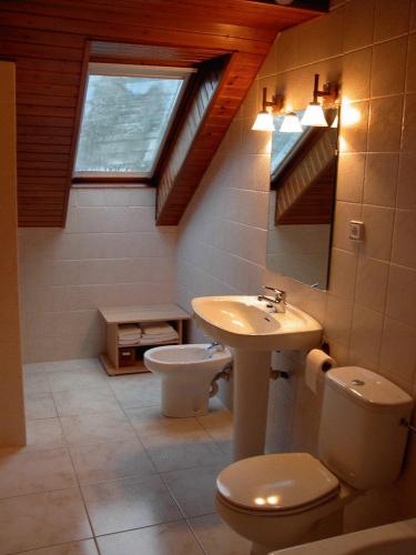 a bathroom with a sink and a toilet and a window at Apartaments El Tarter in Erill la Vall