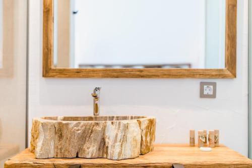 a bathroom with a wooden sink with a mirror at Outsite Ibiza in Es Cana