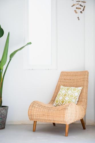 a rattan chair with a pillow in a room at Outsite Ibiza in Es Cana
