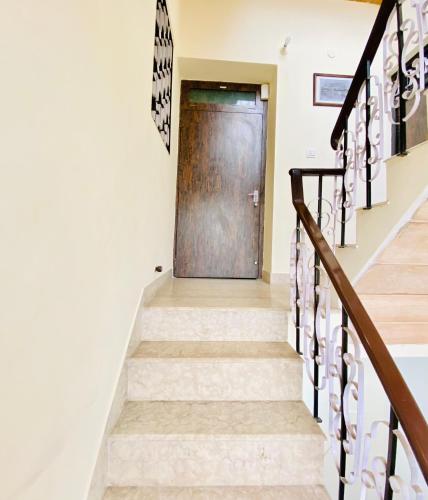 a stairway with a wooden door and a stair case at JAWAHAR VILLA - 2BHK - City Centre in Jodhpur